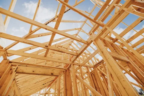 Charpente en bois d’une maison en construction, vue de l’intérieur vers le ciel