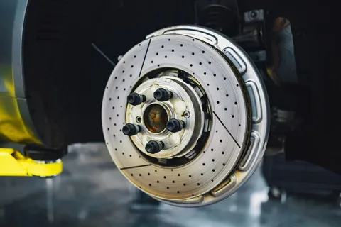 Disque de frein et moyeu d’une voiture roue déposée, sur un pont élévateur d’atelier