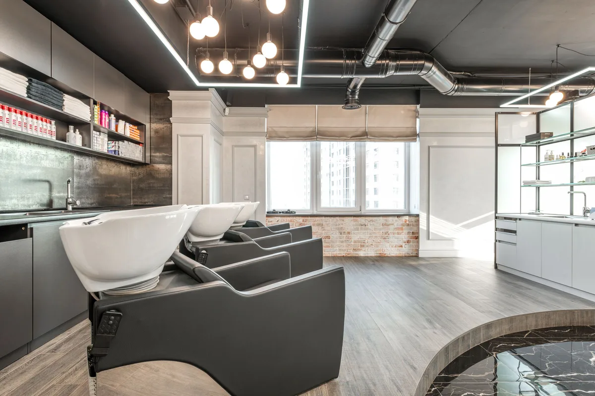 Bacs de lavage et fauteuils inclinables d’un salon de coiffure vide