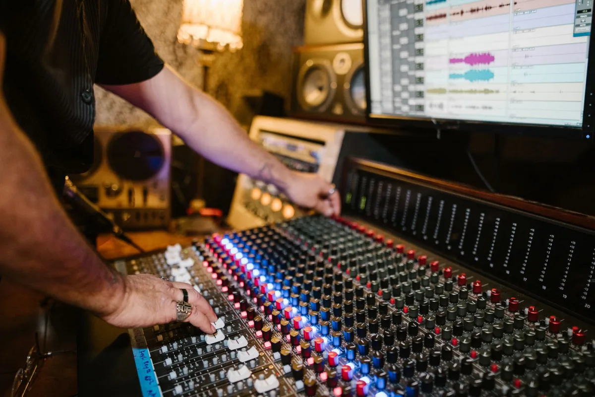 Ingénieur du son réglant les tranches d'une console de mixage en régie