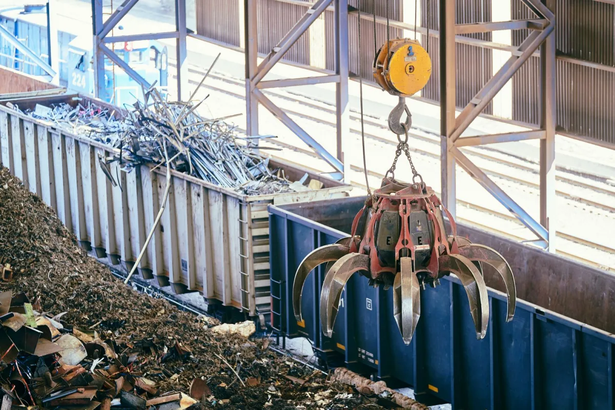 Grappin de manutention chargeant de la ferraille triée dans une benne